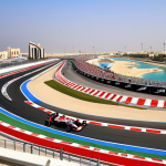 **

A vibrant photograph showcasing the Bahrain International Circuit during the Formula 1 Grand Prix. The stands are packed with cheering fans from around the world, with the sleek, modern race cars speeding down the track. In the background, the iconic Bahrain skyline can be seen, subtly blending the image of tourism and the country's modern infrastructure. The overall feel should be energetic and exciting, highlighting Bahrain's success in attracting international events and boosting tourism. Focus on dynamic movement and bright, eye-catching colors.

**